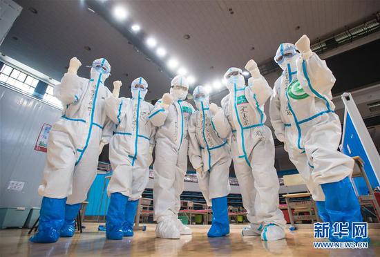 3月10日，武漢武昌方艙醫院正式休艙，醫護人員在送走新冠肺炎治愈患者后合影留念。新華社記者 肖藝九 攝