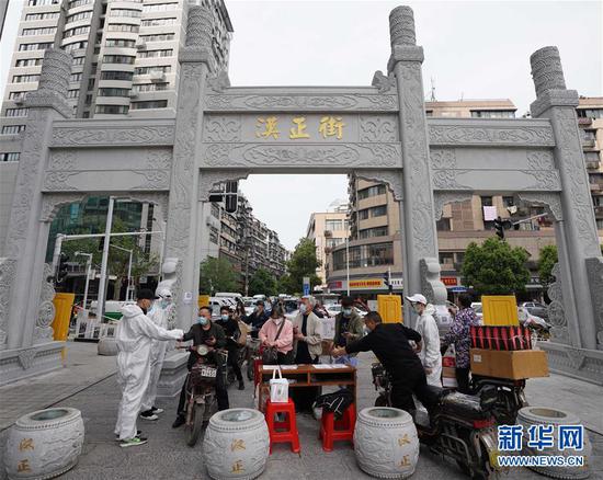  4月16日，進(jìn)出武漢漢正街步行街的人員在掃描健康碼。新華社記者 王毓國 攝
